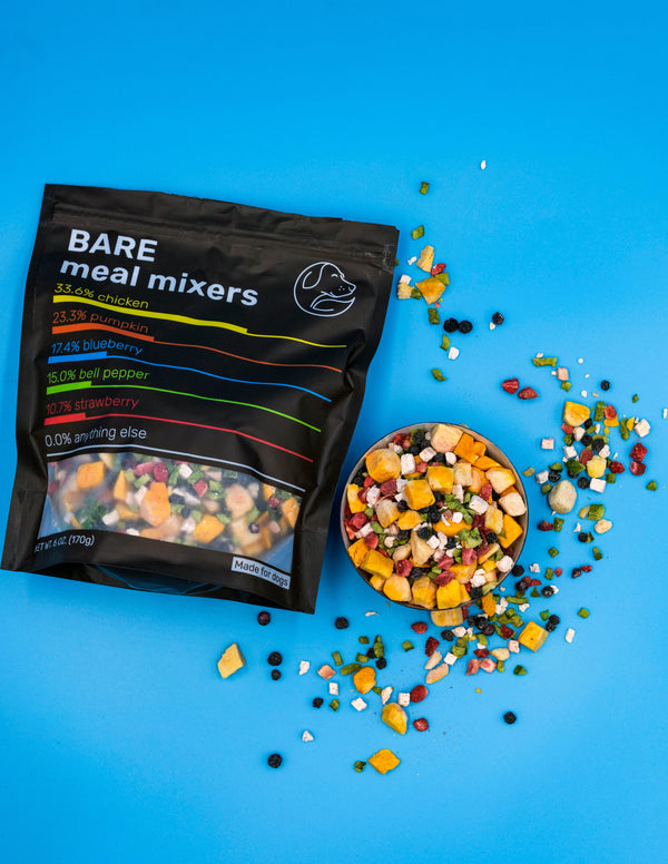 Bare Naked Chicken Mixers packaging with a bowl of colorful pet food on a blue background